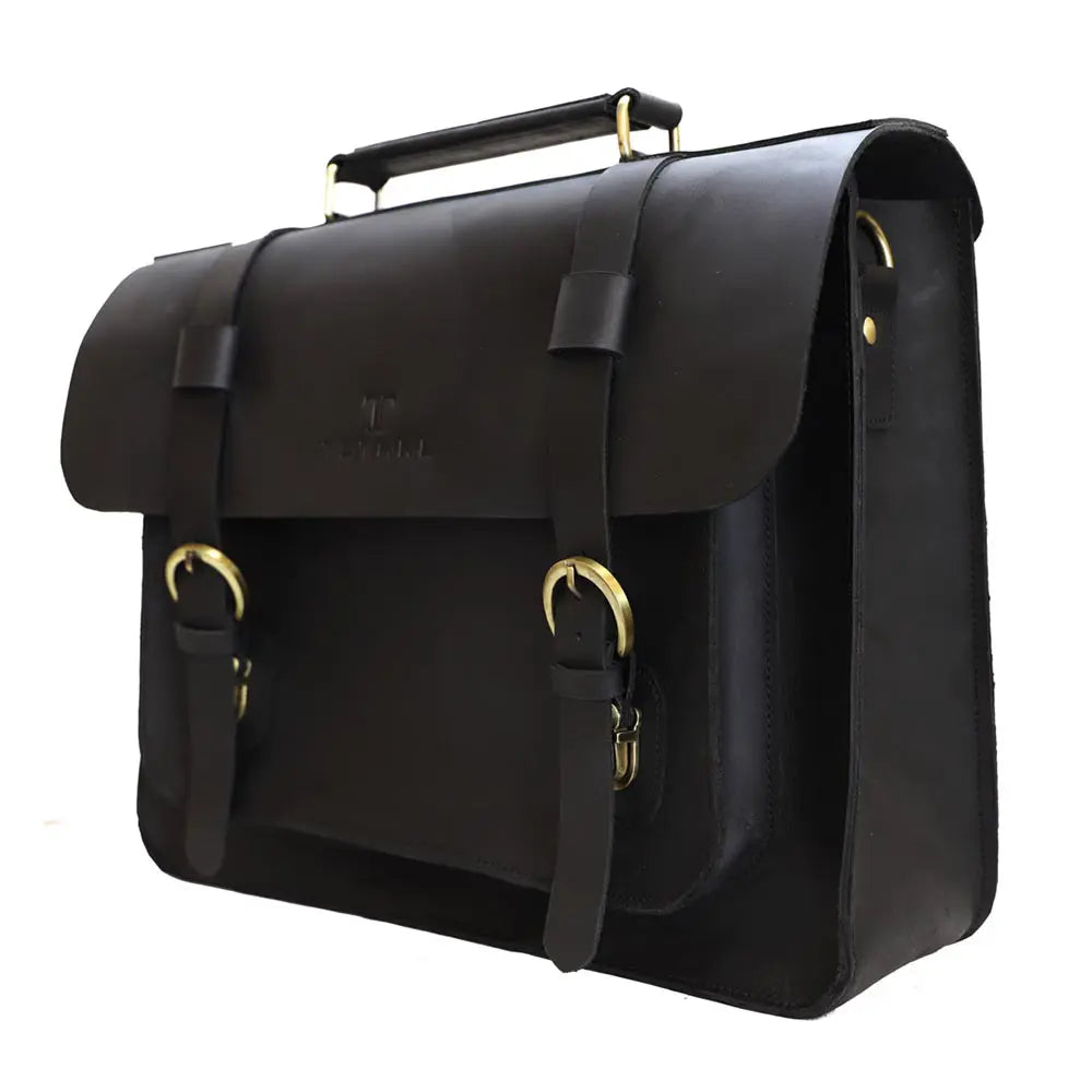 Black leather satchel bag with gold buckles on a white background