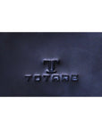 Navy blue leather surface with 'TOTARE' branding