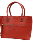 Red leather handbag with gold accents on a white background