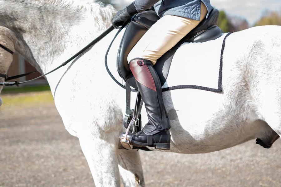 Person riding a white horse on a track