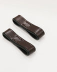 Two brown leather straps on a white background