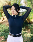 Person wearing a navy long-sleeve top and white pants with a blurred natural background