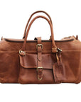 Brown leather duffel bag with gold buckles on a white background
