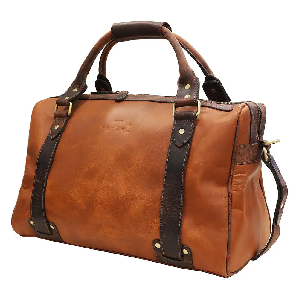 Brown leather duffel bag with gold studs on a white background