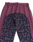 Purple plaid pants with a black patterned bottom section on a white background