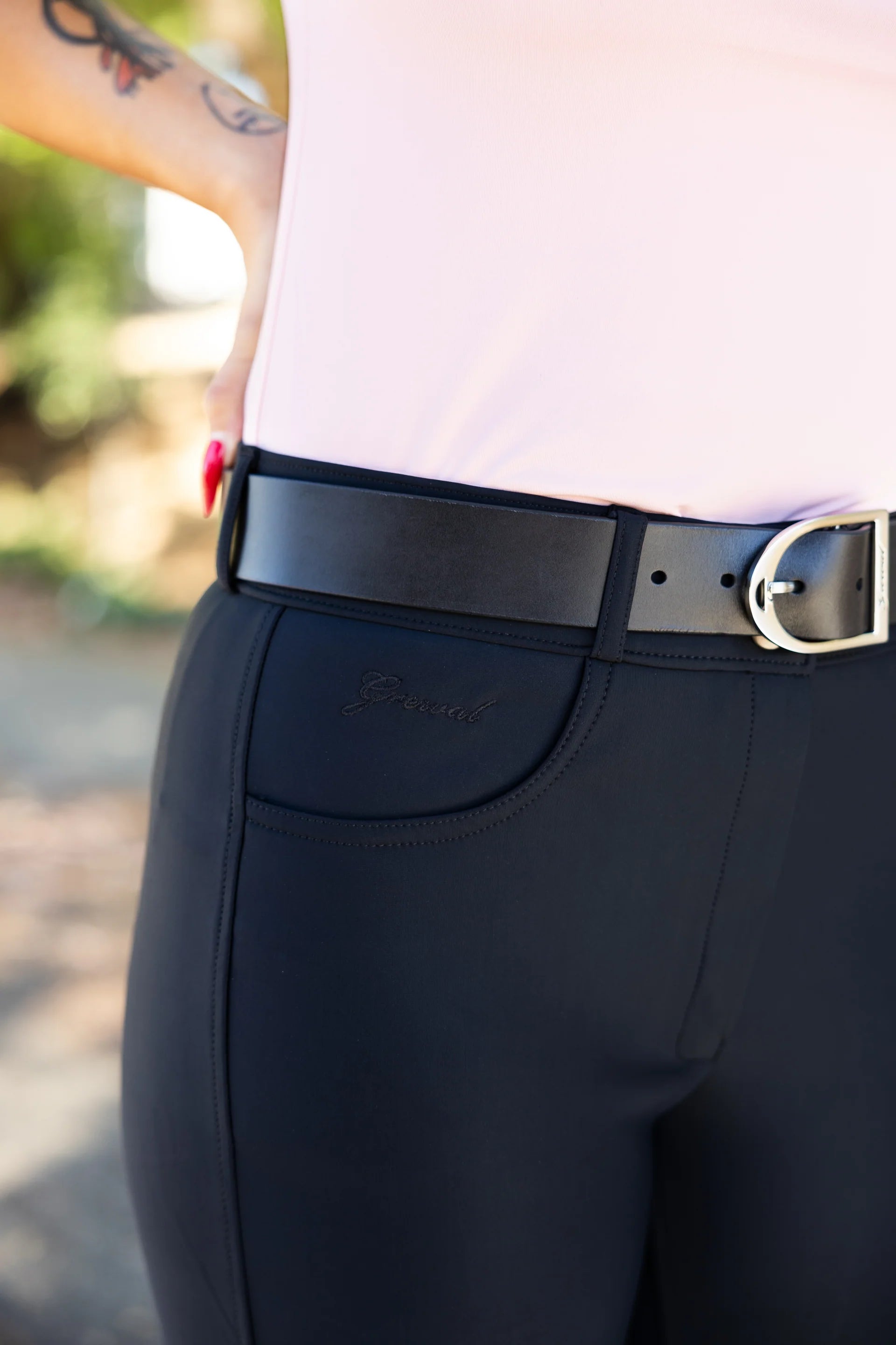 Black riding pants with a black belt featuring a silver buckle.